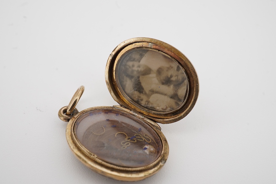 A Victorian gold plated and black enamel set oval mourning locket, 26mm. Condition - poor to fair